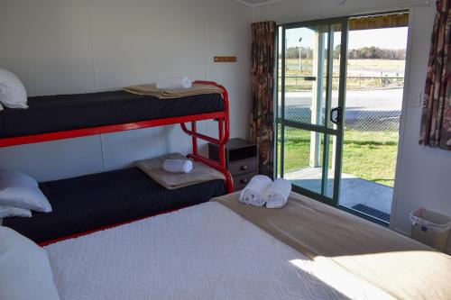 a room with two bunk beds and a sliding glass door at Route79 Holiday Park Geraldine in Geraldine