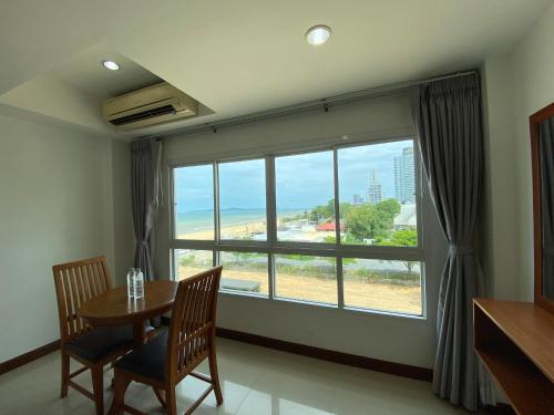 a dining room with a table and a large window at KP Seaview Jomtien in Na Jomtien