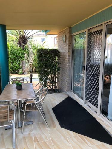a patio with a table and chairs on a porch at Beaches Serviced Apartments in Nelson Bay