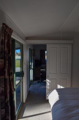 a bedroom with a bed and a door to a living room at Route79 Holiday Park Geraldine in Geraldine