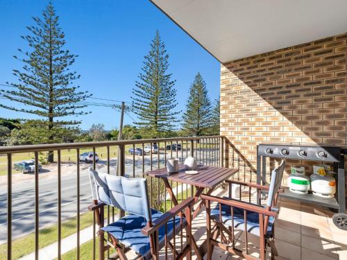 a balcony with a table and chairs and a grill at Seaside Getaway on Kingscliff Beach in Kingscliff