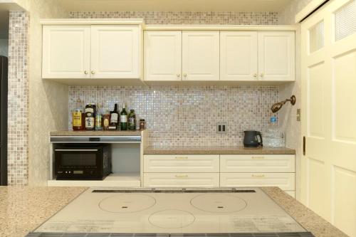 a kitchen with white cabinets and a counter top at Premium Sirayama in Saga