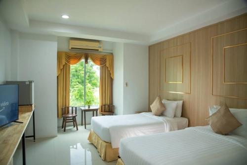 a hotel room with two beds and a television at Gassan Panorama Golf Club in Ban San Pa Hiang