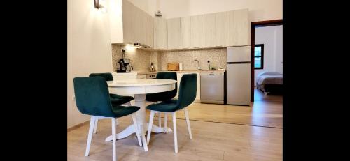 a kitchen with a white table and green chairs at Apartment Bregava in Stolac