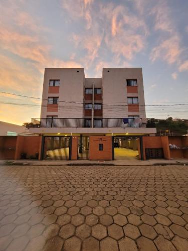 a building with a sunset in front of it at Sapucaia Flat - Apart Hotel in Santa Rita do Sapucaí