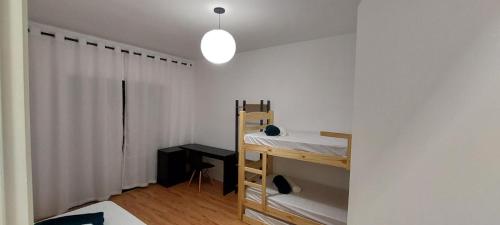 a bedroom with a bunk bed and a white wall at Sapucaia Flat - Apart Hotel in Santa Rita do Sapucaí