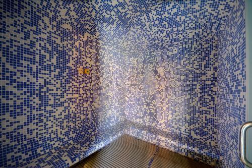 a bathroom with blue and white tiles on the wall at Asfar Resorts Al Ain in Al Ain