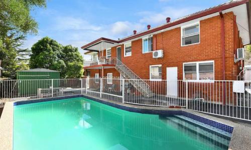 a house with a swimming pool in front of a building at Bexley 5Br near Train & Shpping with pool 10ppl First Floor in Sydney