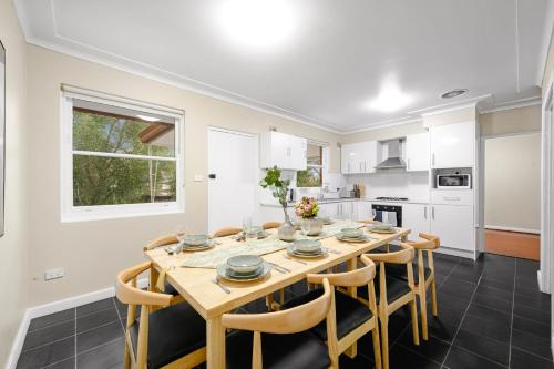 a kitchen and dining room with a wooden table and chairs at Bexley 5Br near Train & Shpping with pool 10ppl First Floor in Sydney