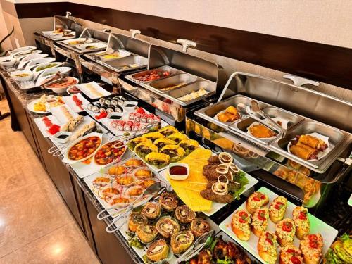 a buffet line with many different types of food at Garden Hotel in Bishkek