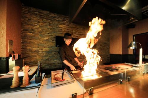 a man cooking food in front of a fire at Bettei Koyoi - Adult Only in Hakone