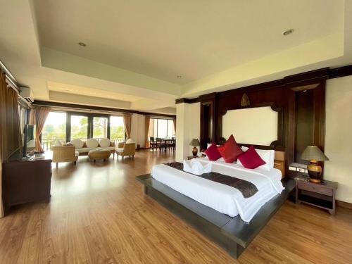 a bedroom with a large bed and a living room at Gassan Legacy Golf Club in Lamphun