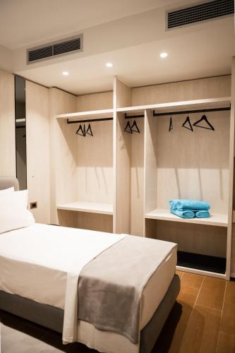 a bedroom with a bed and shelves with towels at JOST Caravel in Vlorë