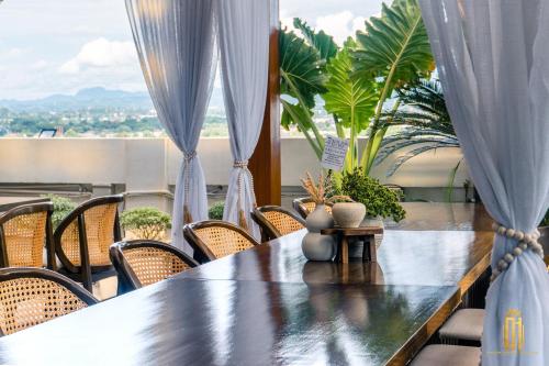 a table with chairs and plants on a balcony at Azzurro Hotel in Angeles