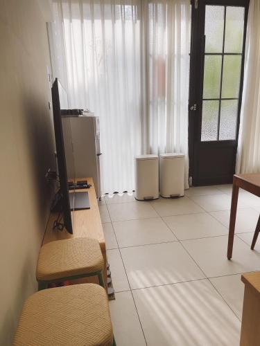 a room with a desk and a television and a door at 梧同包棟民宿La Petite Maison I Entire House BnB I 寵物友善 I 國旅卡 I 出差商旅可報帳 I 電動麻將 I NETFLIX I Nintendo Switch I MOD I一軒家貸切 in Tainan