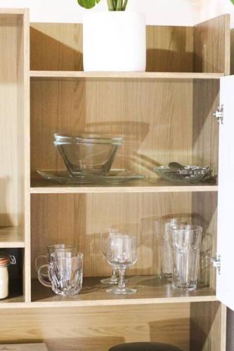 a wooden shelf with glasses and bowls on it at Amelia Inn Apartment in Managua