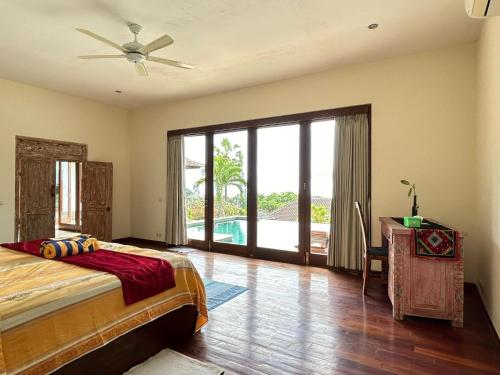 a bedroom with a bed and a desk and a window at Villa Ponjok Batu Residence in Bukti