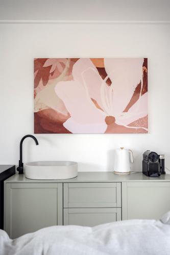 a white desk with a sink and a painting on the wall at Murray Tiny Home Collector in Collector