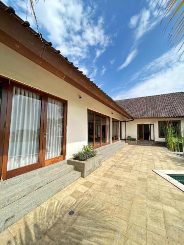 a house with a patio in front of it at Villa Ponjok Batu Residence in Bukti