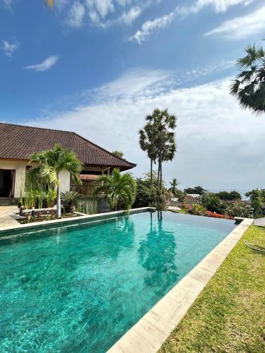 a swimming pool in front of a house at Villa Ponjok Batu Residence in Bukti