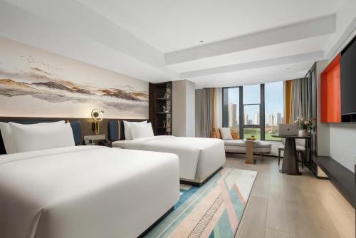 Rúm í herbergi á Mehood Lestie Hotel Maoming High-speed Railway