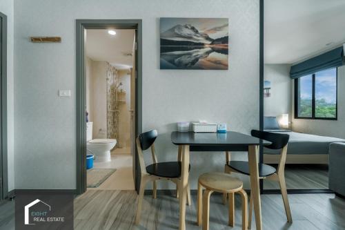 - une salle à manger avec une table, des chaises et un lit dans l'établissement Cozy Studio Apartment at Naiyang Beach G507, à Phuket