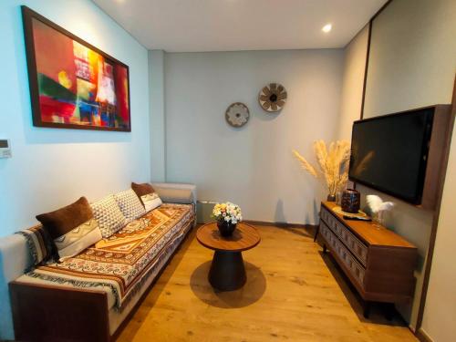 a living room with a couch and a flat screen tv at Apec Mandala Chambay Mũi Né in Ấp Thiẹn Ái