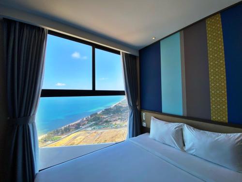 a bed in a room with a large window at Apec Mandala Chambay Mũi Né in Ấp Thiẹn Ái