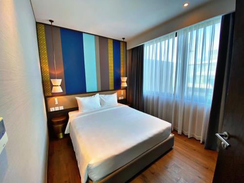 a bedroom with a large bed and a large window at Apec Mandala Chambay Mũi Né in Ấp Thiẹn Ái