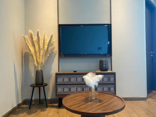 a living room with a tv and a table with feathers on it at Apec Mandala Chambay Mũi Né in Ấp Thiẹn Ái