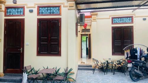 a building with doors and chairs and a motorcycle parked outside at Hoang Giang Homestay in Ninh Binh