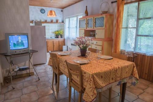 - une cuisine avec une table et une télévision dans la chambre dans l'établissement Location de vacances a masmejean, à Villeneuve