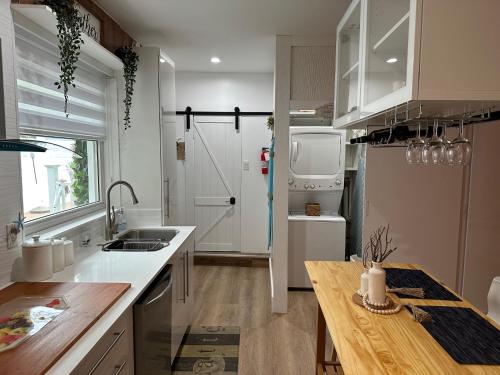 a kitchen with white cabinets and a wooden table at Studio Apartment 5 minutes from beach in St Petersburg