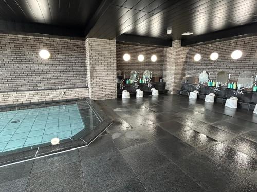 a large bathroom with a swimming pool and mirrors at Hotel Route-Inn Kanazawa Ekimae in Kanazawa