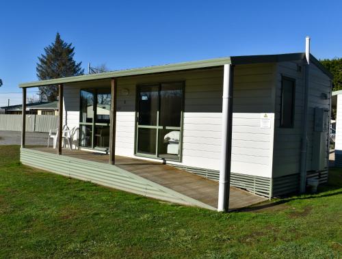 a small house with a deck in the grass at Route79 Holiday Park Geraldine in Geraldine