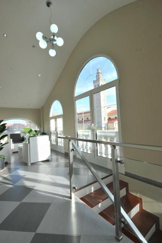 a lobby with a staircase and a large window at Rose Garden Hotel in Shkodër