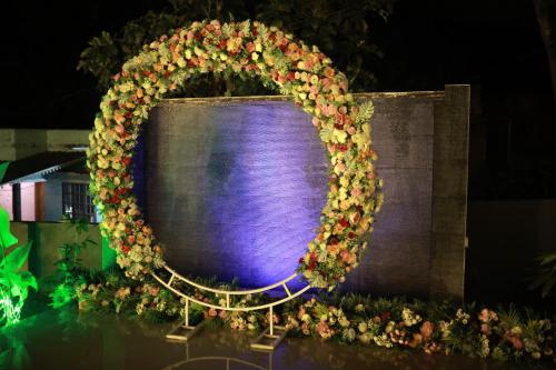 a wreath of flowers on a wall with a purple screen at Private Villa in Kollam with Pool in Kollam