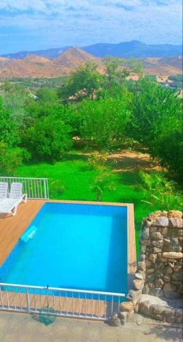 a swimming pool on a deck with a view of the mountains at Mukhadgverdi in Itʼkhvisi