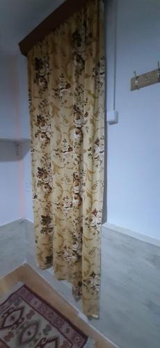 a curtain in a room with a rug on the floor at Guest House Nise in Tbilisi City