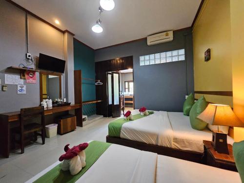 a bedroom with two beds with stuffed animals sitting on them at Araya Boutique Hotel in Thongsala