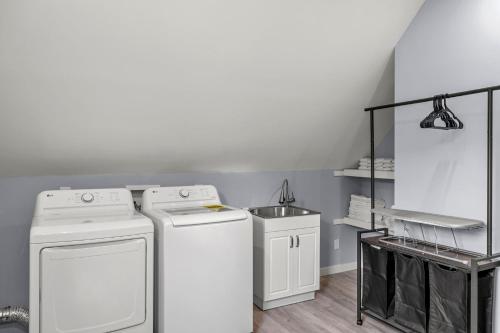 a laundry room with two washing machines and a sink at Central Indy 5BD - Pingpong - Outdoor Movie - BBQ in Indianapolis