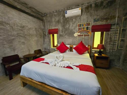 a bedroom with a large bed with red pillows at Araya Boutique Hotel in Thongsala