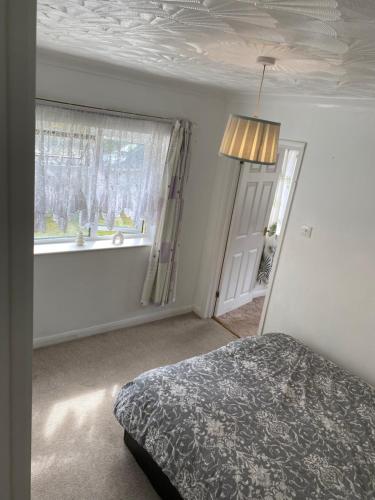 a bedroom with a bed and a window at Guest house in Dartford in Dartford