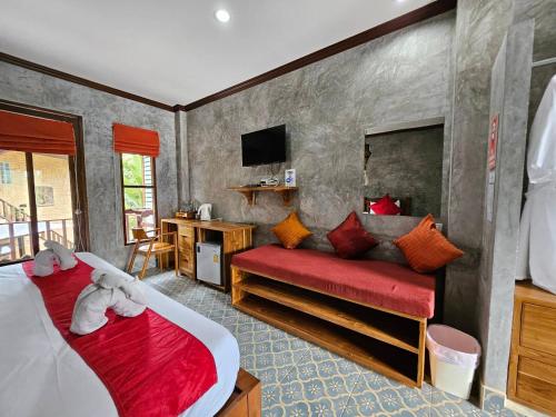a bedroom with two beds and a red couch at Araya Boutique Hotel in Thongsala