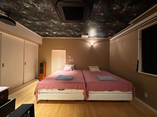 a bedroom with a large bed with a painting on the ceiling at ヴィラマーレ熱海（Villa Mare Atami） in Atami