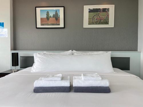 a bedroom with a white bed with towels on it at KP Seaview Jomtien in Na Jomtien