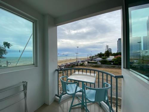 a balcony with a table and chairs and a view of the beach at KP Seaview Jomtien in Na Jomtien