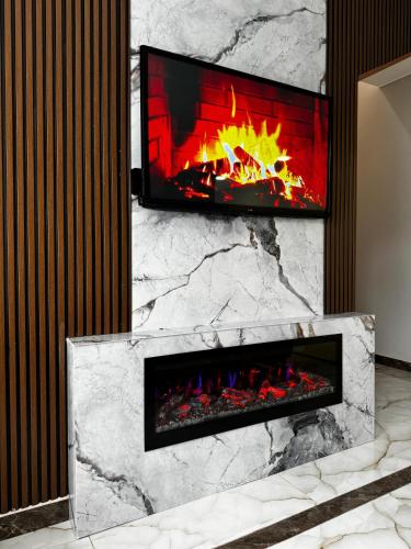 a fireplace with a tv on top of it at Luxury Milan Mountain Ponoramic Villa, indoor heated pool and jacuzzi with mountain view in Gabala