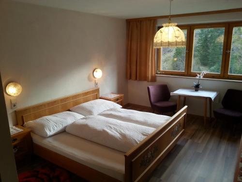 a bedroom with a bed and a desk and a window at Gasthof Bergheimat in Boden