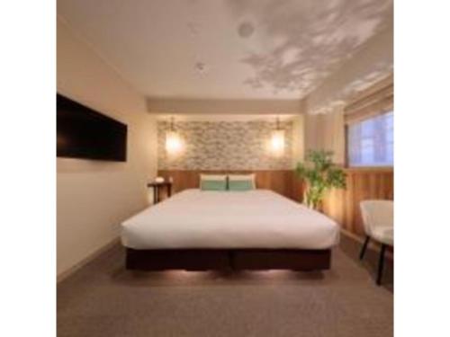 een slaapkamer met een wit bed en een televisie bij Gion Crystal Hotel - Vacation STAY 21877v in Kyoto